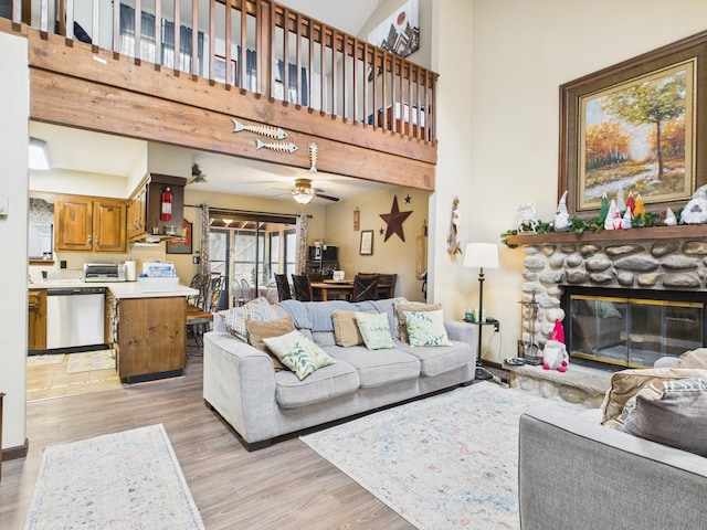 179 Choctaw Dr, Pocono Lake, PA 18347 - living area with a toaster, light wood-type flooring, a stone fireplace, and a high ceiling