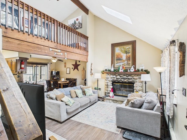179 Choctaw Dr, Pocono Lake, PA 18347 - living area with high vaulted ceiling, a stone fireplace, wood finished floors, and a skylight