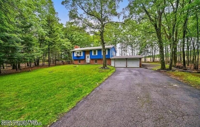 view of front of property with aphalt driveway, a chimney, and a front yard