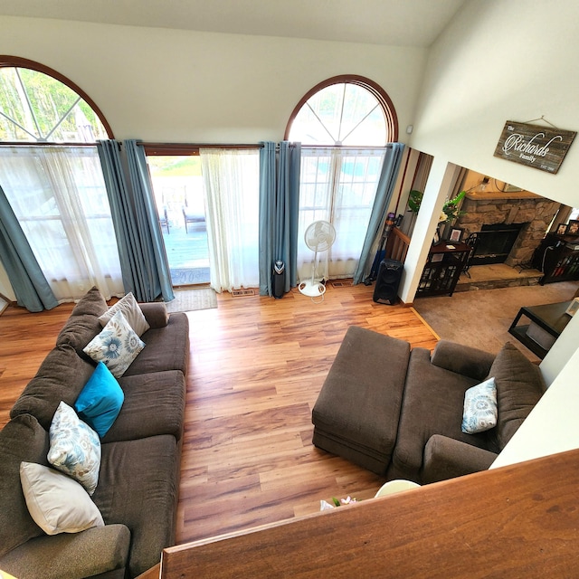 408 Sassafrass Way, Stroudsburg, PA 18360 - living area featuring wood finished floors, a stone fireplace, and high vaulted ceiling