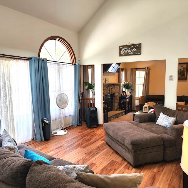 408 Sassafrass Way, Stroudsburg, PA 18360 - living area featuring wood finished floors, high vaulted ceiling, a fireplace, and plenty of natural light