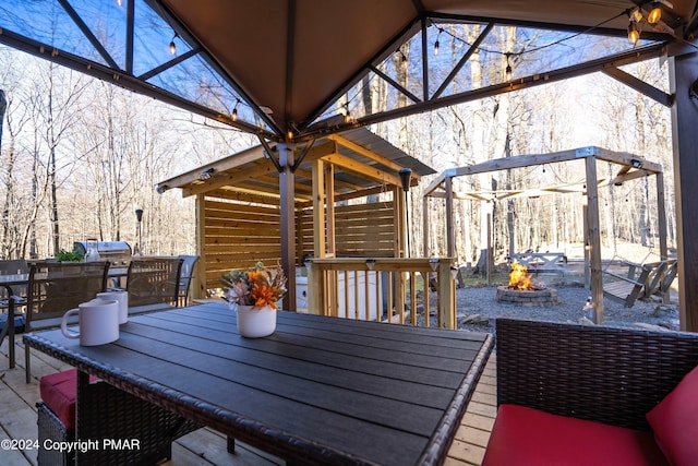 deck featuring outdoor dining space and an outdoor fire pit
