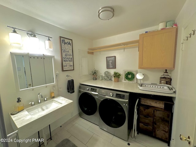 washroom with washing machine and clothes dryer, light tile patterned flooring, laundry area, and a sink
