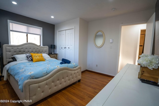 bedroom with recessed lighting, baseboards, wood finished floors, and a closet
