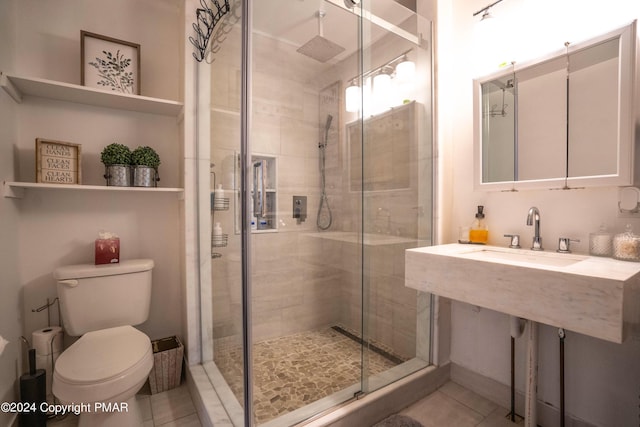 full bathroom featuring tile patterned flooring, a sink, toilet, and a shower stall