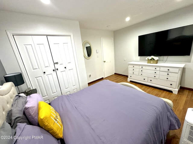 bedroom featuring baseboards, a closet, recessed lighting, and wood finished floors