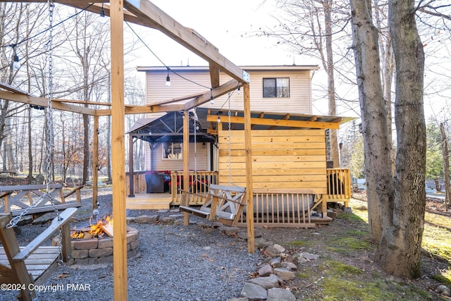 exterior space featuring a wooden deck and a fire pit