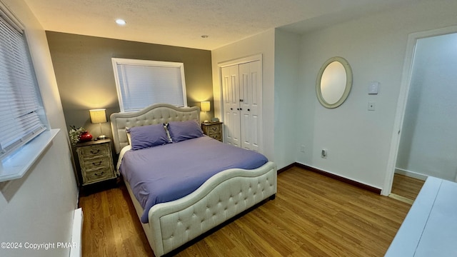 bedroom featuring baseboards, a closet, recessed lighting, and wood finished floors