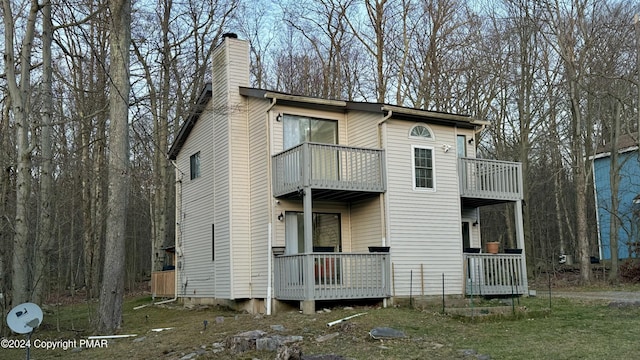 view of property exterior with a chimney and a balcony