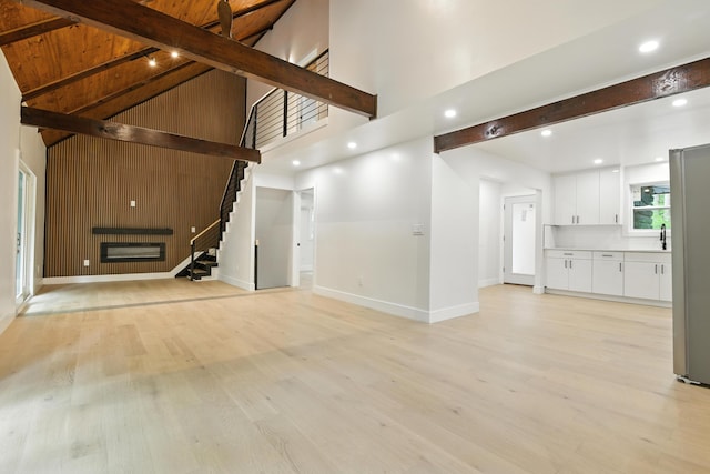 16 Norman Dr, East Stroudsburg, PA 18302 - unfurnished living room featuring beam ceiling, light wood-style floors, stairs, recessed lighting, and high vaulted ceiling