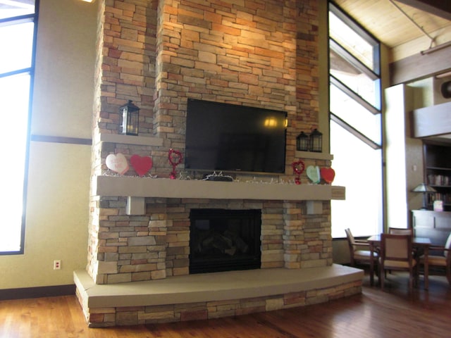 living area featuring a healthy amount of sunlight, a fireplace, and wood finished floors