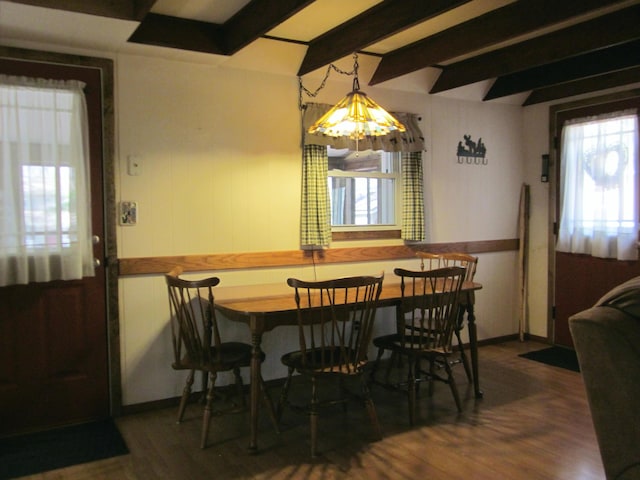 dining space with beam ceiling and wood finished floors