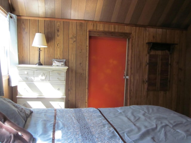 bedroom with wood ceiling and wood walls