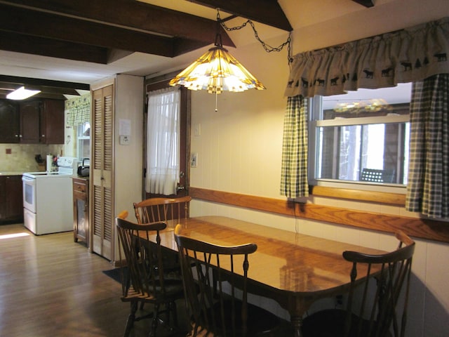 dining room featuring lofted ceiling with beams, wood finished floors, and a healthy amount of sunlight
