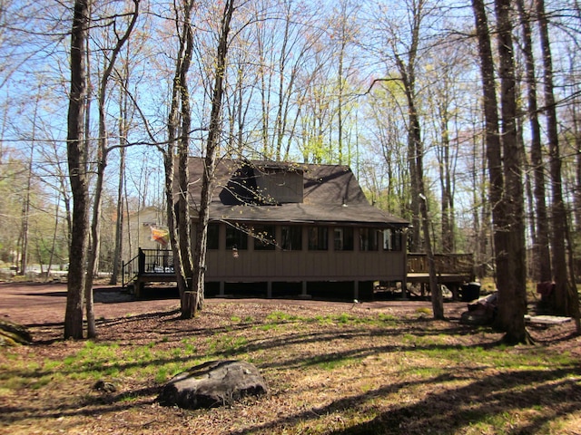 exterior space with roof with shingles and a deck