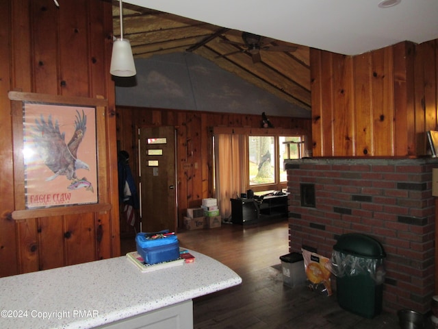 living area with vaulted ceiling with beams, wood walls, a ceiling fan, and wood finished floors