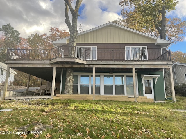 rear view of property with a yard and a wooden deck