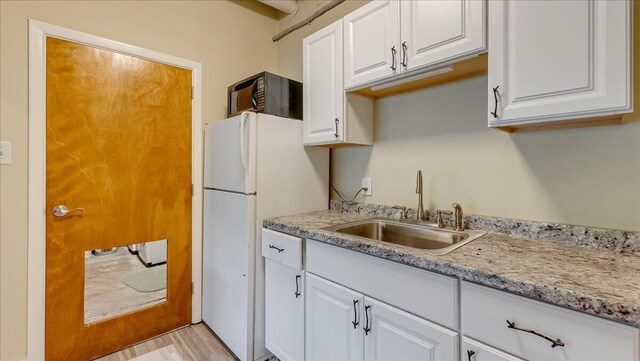 300 Indian Lake Trl, White Haven, PA 18661 - kitchen with freestanding refrigerator, a sink, white cabinetry, and black microwave
