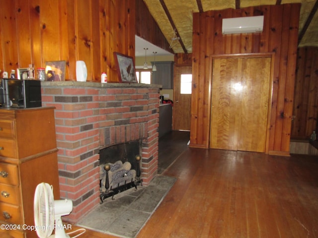 living room featuring wood walls, a fireplace, wood finished floors, and a wall mounted AC