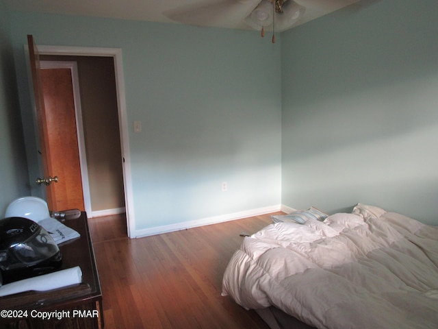 bedroom featuring baseboards and wood finished floors