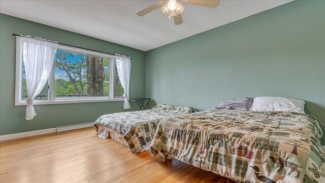 300 Indian Lake Trl, White Haven, PA 18661 - bedroom with a baseboard radiator, wood finished floors, a ceiling fan, and baseboards