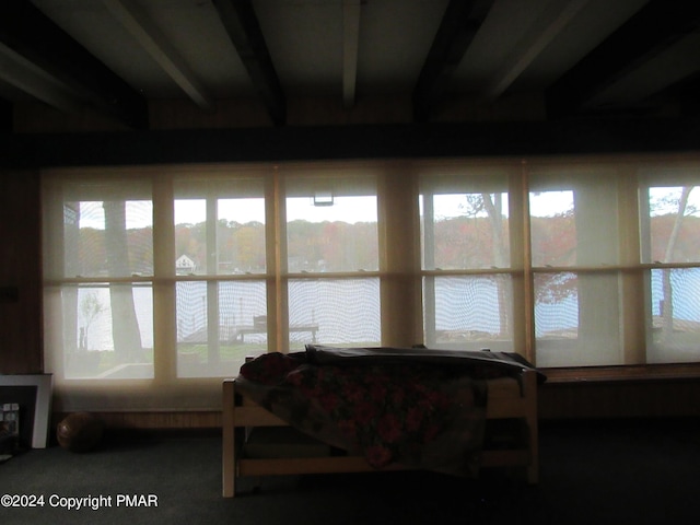 sunroom with a water view and beamed ceiling