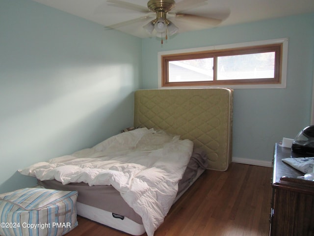 bedroom with ceiling fan, wood finished floors, and baseboards