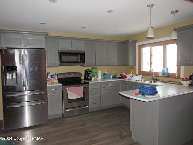 kitchen featuring a peninsula, a sink, light countertops, appliances with stainless steel finishes, and gray cabinets