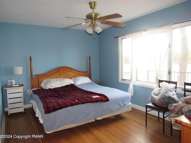 bedroom featuring ceiling fan, baseboards, and wood finished floors