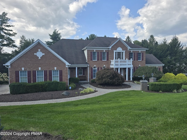 colonial home featuring a front lawn and brick siding