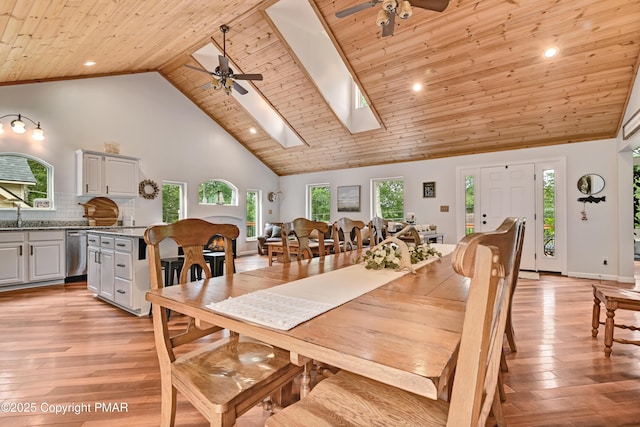 dining room with a skylight, wooden ceiling, and light wood-style flooring