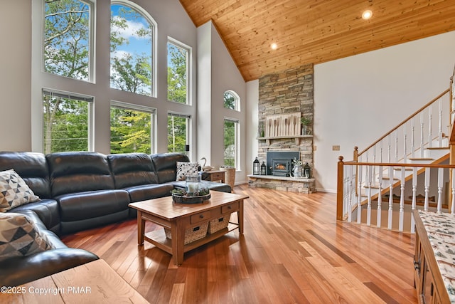 living area with baseboards, wood ceiling, stairway, hardwood / wood-style floors, and high vaulted ceiling