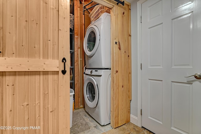 clothes washing area with stacked washer / dryer