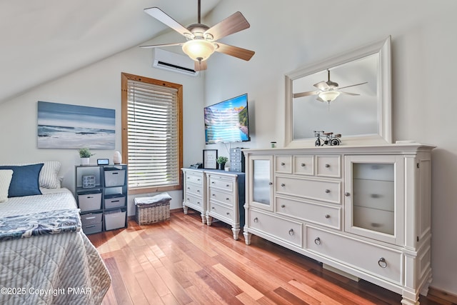 bedroom featuring lofted ceiling, ceiling fan, light wood finished floors, and a wall unit AC