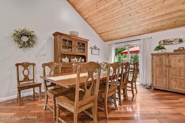 dining room with high vaulted ceiling, wooden ceiling, and light hardwood / wood-style floors