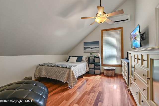 bedroom featuring ceiling fan, a wall mounted air conditioner, vaulted ceiling, and wood finished floors