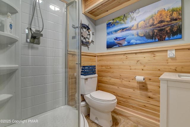 bathroom with toilet, wood walls, vanity, a shower, and wainscoting