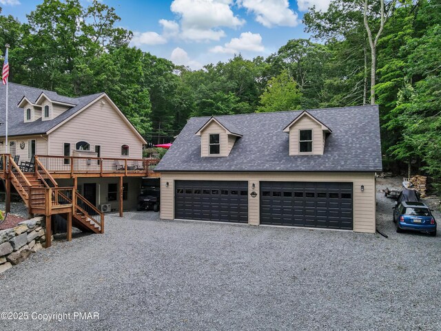 cape cod home featuring a garage and a wooden deck