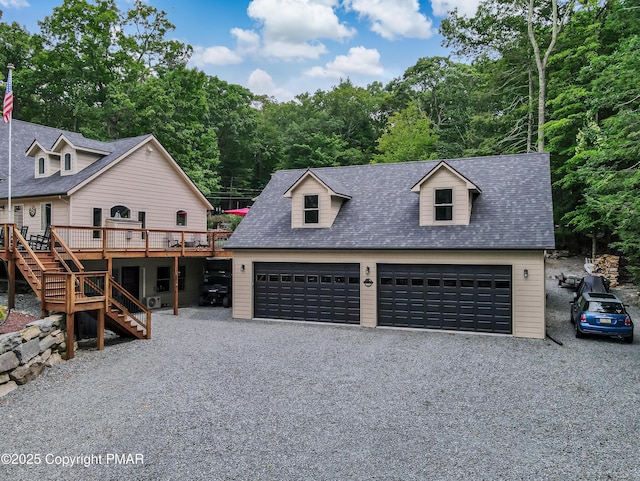 cape cod home featuring a garage, stairway, a deck, and roof with shingles