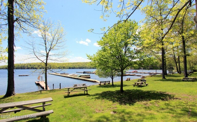 view of community featuring a yard and a water view