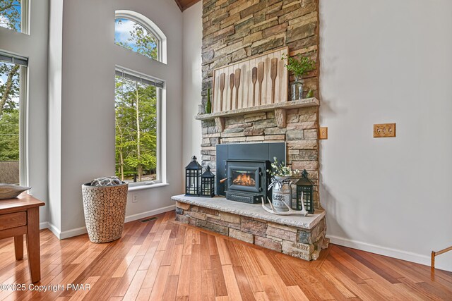 sitting room with a towering ceiling, wood-type flooring, and plenty of natural light