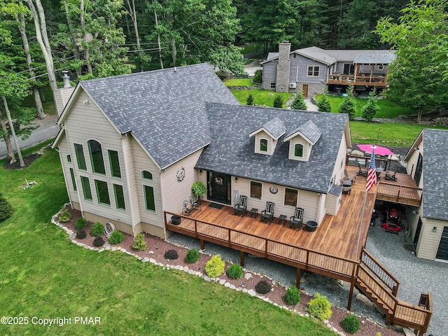 rear view of house with a yard and a wooden deck