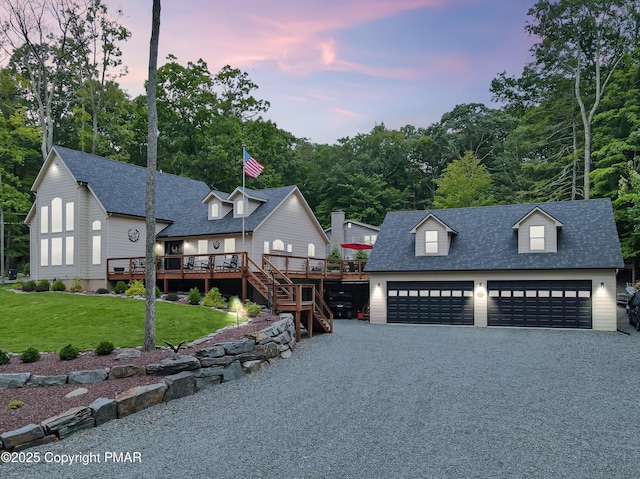 modern farmhouse with a wooden deck, a garage, and a lawn