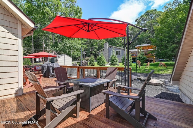 wooden terrace featuring an outdoor fire pit