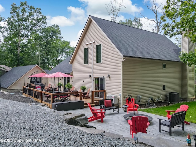 back of house with a patio area, roof with shingles, a wooden deck, and central AC unit