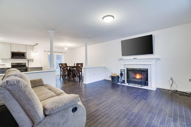 9436 Juniper Dr, Tobyhanna, PA 18466 - living area featuring dark wood finished floors, decorative columns, and a fireplace with flush hearth