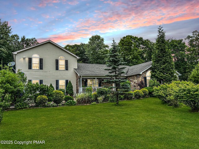 view of front of property with a lawn and a porch