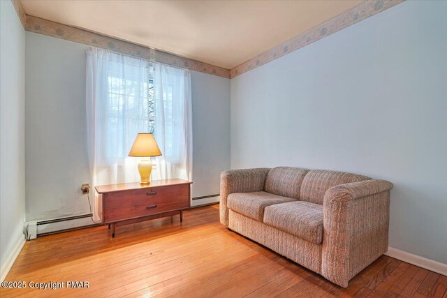 sitting room featuring a baseboard radiator and wood-type flooring