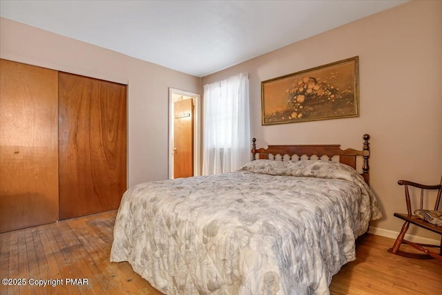 bedroom with light wood-type flooring and a closet