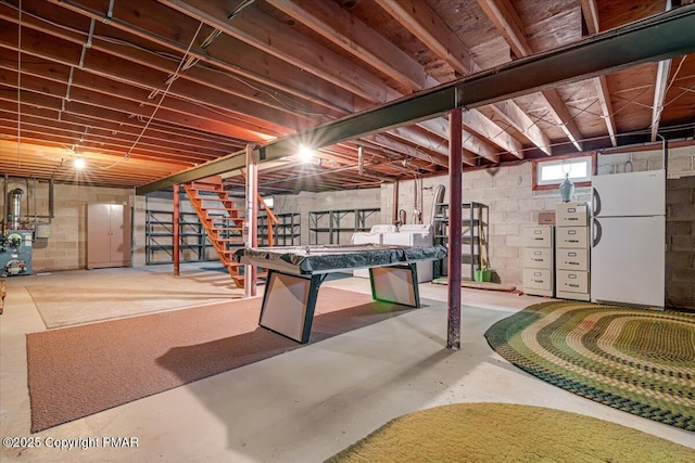 basement with washer / dryer and white fridge